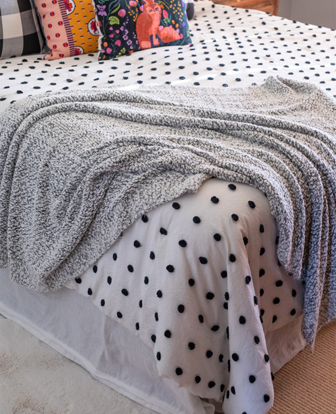 Black and white wubby blanket drapes across the bed